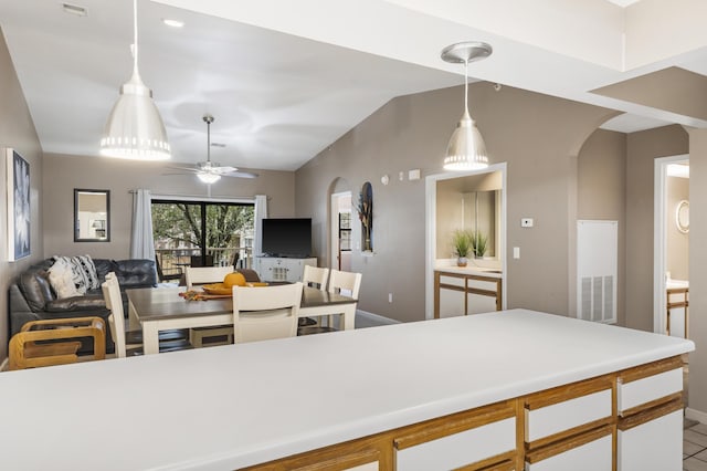 350 Wildwood Dr S Unit 31, Branson, MO 65616 - kitchen featuring arched walkways, open floor plan, vaulted ceiling, light countertops, and hanging light fixtures