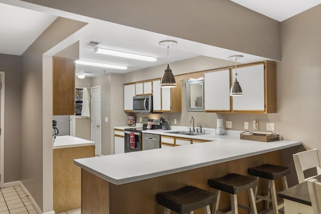 350 Wildwood Dr S Unit 31, Branson, MO 65616 - kitchen featuring appliances with stainless steel finishes, a peninsula, light countertops, and decorative light fixtures