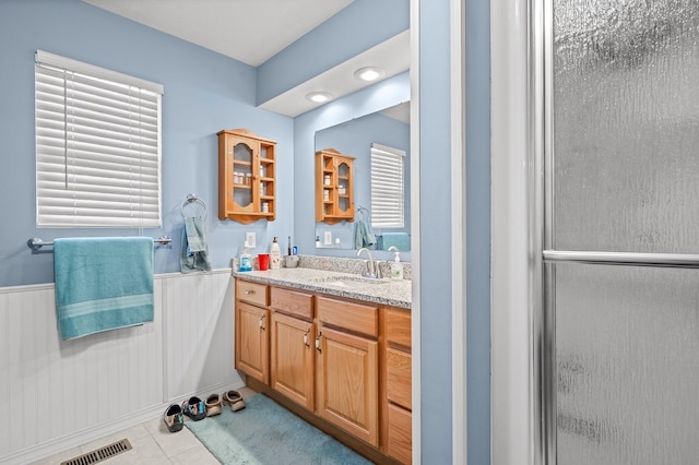 105 W Oak St, Nixa, MO 65714 - bathroom with wainscoting, vanity, a stall shower, and tile patterned floors