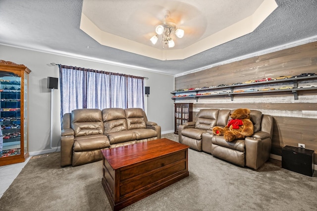 105 W Oak St, Nixa, MO 65714 - carpeted living area featuring ceiling fan, a raised ceiling, a textured ceiling, ornamental molding, and wooden walls