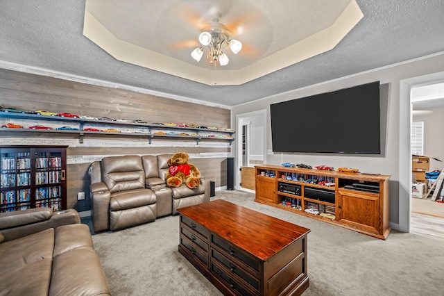 105 W Oak St, Nixa, MO 65714 - living room featuring a ceiling fan, light colored carpet, a raised ceiling, wooden walls, and a textured ceiling