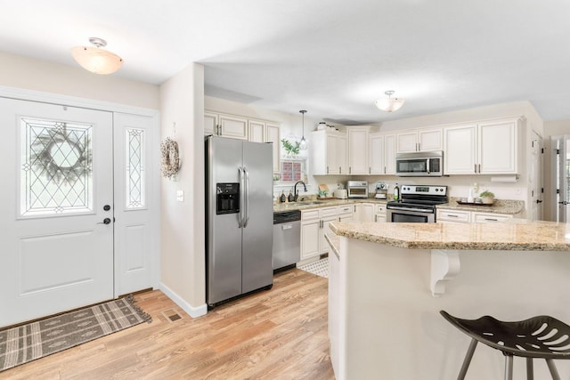 1865 Morningside Falls Blvd, Blue Eye, MO 65611 - kitchen featuring appliances with stainless steel finishes, light wood-style floors, a kitchen bar, and healthy amount of natural light