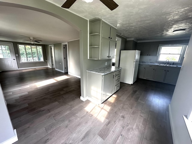 2609 W Lombard St, Springfield, MO 65802 - kitchen with freestanding refrigerator, ceiling fan, arched walkways, dark wood-style floors, and a textured ceiling
