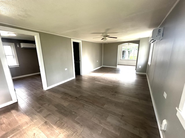 2609 W Lombard St, Springfield, MO 65802 - spare room featuring a wall mounted air conditioner, ceiling fan, dark wood-type flooring, and arched walkways