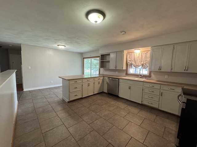 606 E Prairie Ln, Ash Grove, MO 65604 - kitchen with stainless steel dishwasher, a peninsula, dark tile patterned floors, open shelves, and light countertops