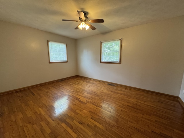606 E Prairie Ln, Ash Grove, MO 65604 - empty room with plenty of natural light, ceiling fan, and wood finished floors
