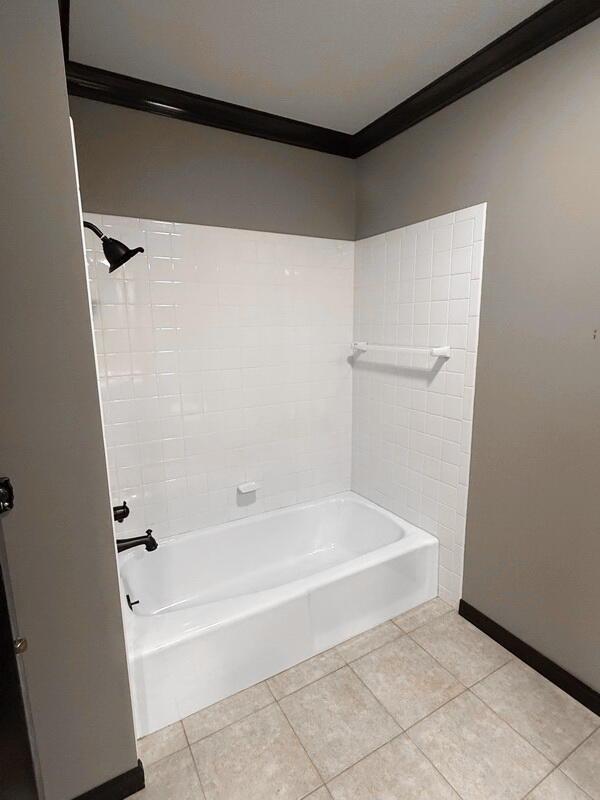 114 W Carman Rd, El Dorado Springs, MO 64744 - full bath featuring tile patterned floors, crown molding, and bathtub / shower combination