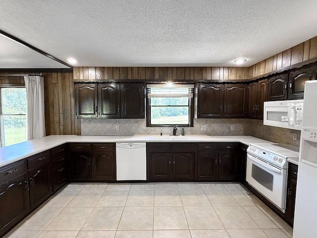 114 W Carman Rd, El Dorado Springs, MO 64744 - kitchen featuring white appliances, light countertops, a textured ceiling, tasteful backsplash, and dark brown cabinetry