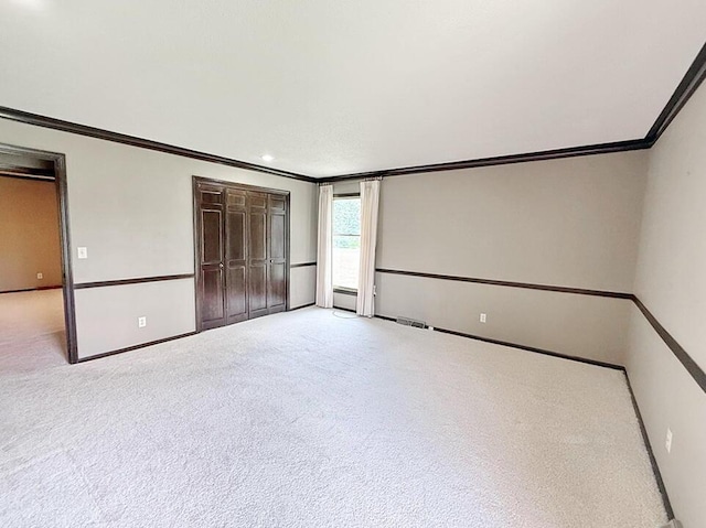 114 W Carman Rd, El Dorado Springs, MO 64744 - unfurnished bedroom with crown molding, carpet, baseboard heating, and a closet