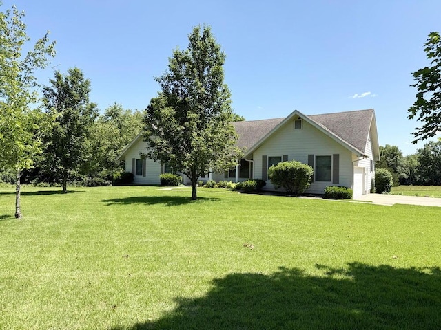 114 W Carman Rd, El Dorado Springs, MO 64744 - view of front of house featuring a front yard, driveway, a garage, and a shingled roof