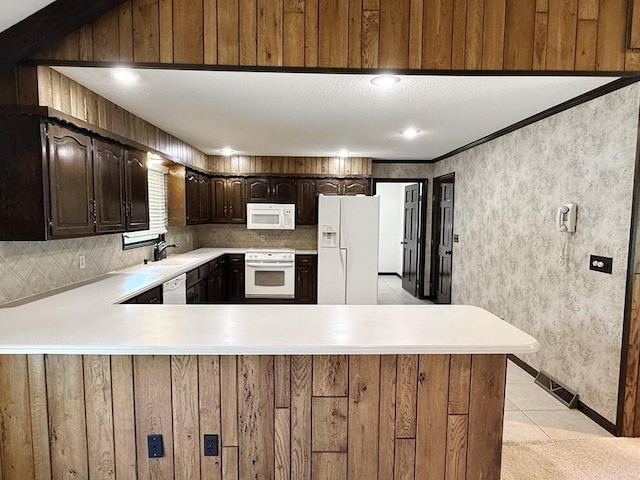114 W Carman Rd, El Dorado Springs, MO 64744 - kitchen featuring white appliances, light countertops, dark brown cabinets, and tasteful backsplash