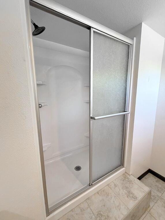 114 W Carman Rd, El Dorado Springs, MO 64744 - full bath with a stall shower, a textured ceiling, and tile patterned flooring