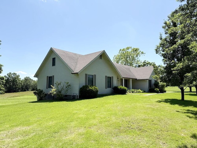 114 W Carman Rd, El Dorado Springs, MO 64744 - view of front facade featuring a front lawn and a shingled roof