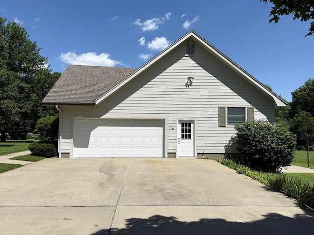 114 W Carman Rd, El Dorado Springs, MO 64744 - view of home's exterior featuring an attached garage and concrete driveway