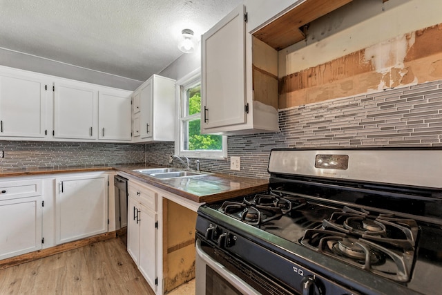 621 E Cleveland St, Seymour, MO 65746 - kitchen with stainless steel range with gas stovetop, light wood-style floors, backsplash, dishwasher, and white cabinetry