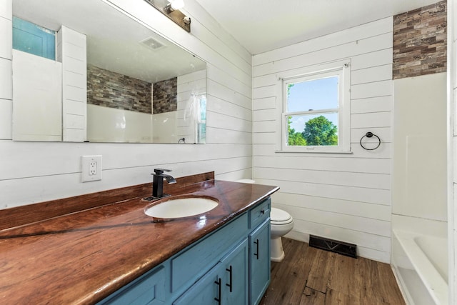 621 E Cleveland St, Seymour, MO 65746 - bathroom with wood finished floors, vanity, wood walls, and shower / washtub combination