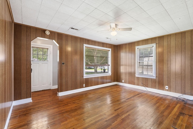 1524 S Thelma Ave, Springfield, MO 65807 - spare room with arched walkways, hardwood / wood-style floors, ceiling fan, and wooden walls