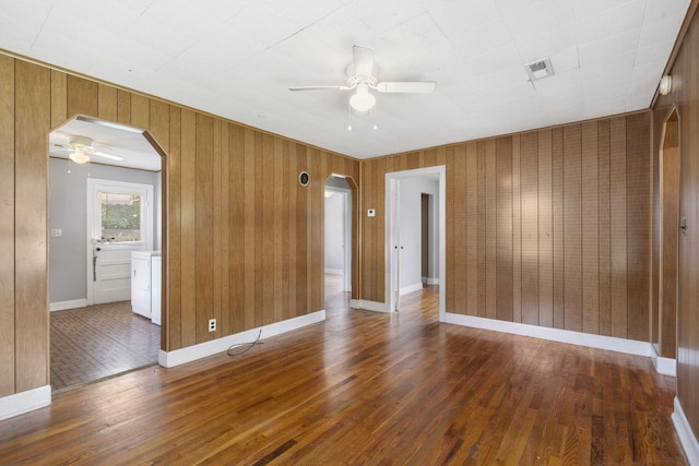1524 S Thelma Ave, Springfield, MO 65807 - spare room with arched walkways, a ceiling fan, wood-type flooring, and wooden walls