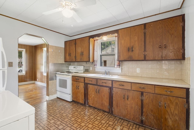 1524 S Thelma Ave, Springfield, MO 65807 - kitchen with white electric stove, arched walkways, light countertops, backsplash, and ornamental molding