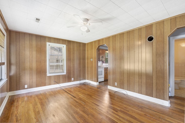 1524 S Thelma Ave, Springfield, MO 65807 - empty room with arched walkways, ceiling fan, wood-type flooring, and wood walls