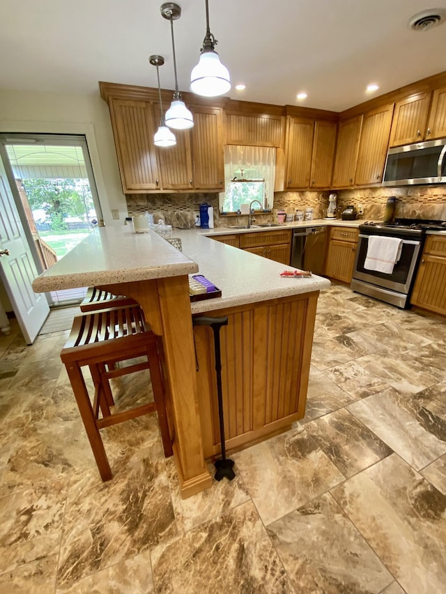 1605 S Park Ave, Aurora, MO 65605 - kitchen featuring appliances with stainless steel finishes, a peninsula, light countertops, and backsplash