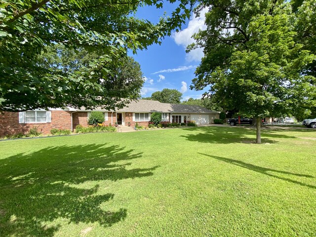 1605 S Park Ave, Aurora, MO 65605 - view of front facade featuring a garage, brick siding, and a front yard