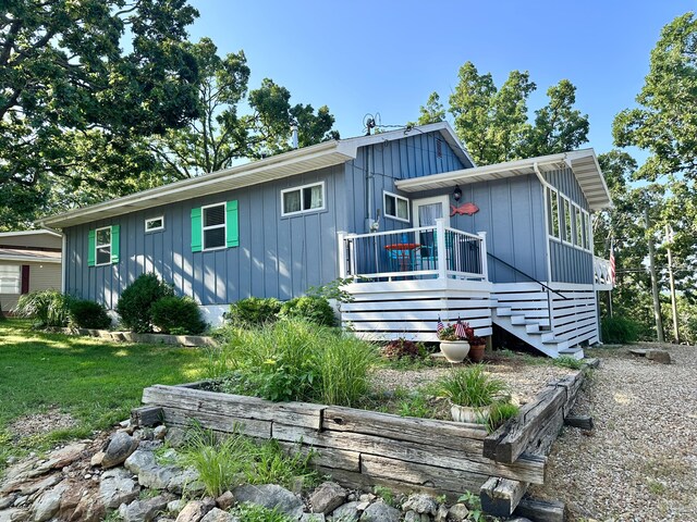 25795 Canyon Dr, Hermitage, MO 65668 - view of front of house with stairs, board and batten siding, and a deck
