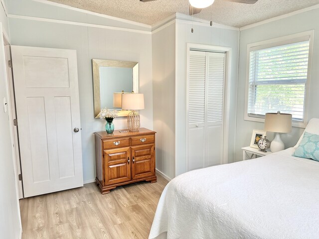 25795 Canyon Dr, Hermitage, MO 65668 - bedroom featuring ornamental molding, light wood finished floors, a closet, a textured ceiling, and ceiling fan