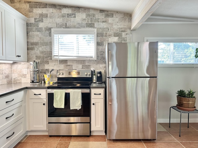 25795 Canyon Dr, Hermitage, MO 65668 - kitchen with appliances with stainless steel finishes, light tile patterned floors, white cabinets, decorative backsplash, and dark countertops