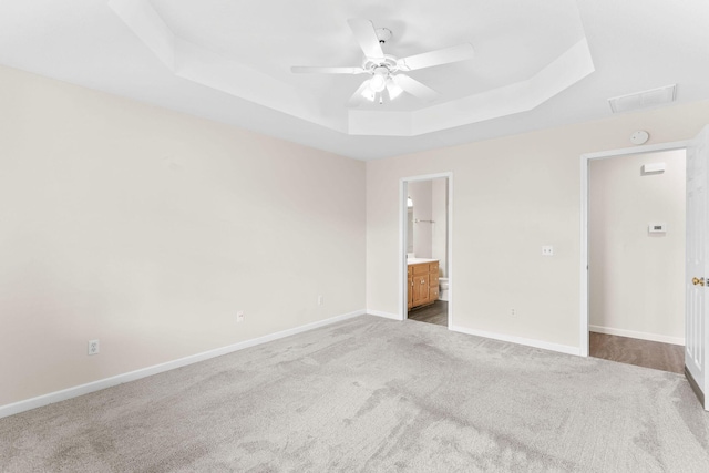 604 N Ellen St, Nixa, MO 65714 - unfurnished bedroom featuring a tray ceiling, carpet flooring, connected bathroom, and a ceiling fan