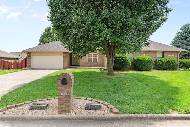 604 N Ellen St, Nixa, MO 65714 - view of property hidden behind natural elements with concrete driveway, a garage, brick siding, and roof with shingles