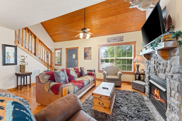 23 Olivia Ct Unit 103A, Branson West, MO 65737 - living area with a stone fireplace, vaulted ceiling, wood finished floors, stairs, and a ceiling fan