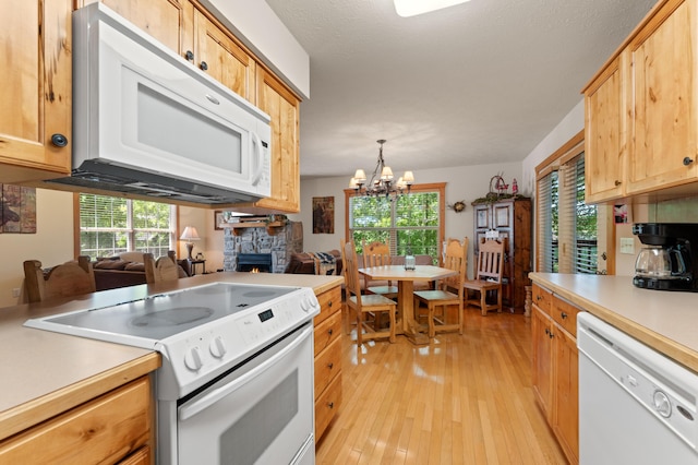 23 Olivia Ct Unit 103A, Branson West, MO 65737 - kitchen featuring white appliances, light wood-style flooring, a fireplace, light countertops, and a chandelier