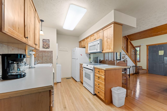 23 Olivia Ct Unit 103A, Branson West, MO 65737 - kitchen featuring white appliances, a textured ceiling, light wood-style floors, light countertops, and decorative backsplash