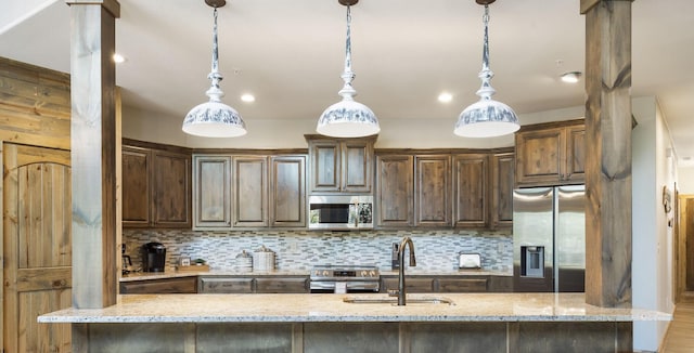 208 Jax Trl, Branson, MO 65616 - kitchen featuring appliances with stainless steel finishes, tasteful backsplash, light stone counters, and dark brown cabinets