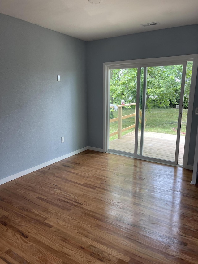 1506 6th St, Monett, MO 65708 - empty room with healthy amount of natural light, dark wood-style floors, and a textured wall