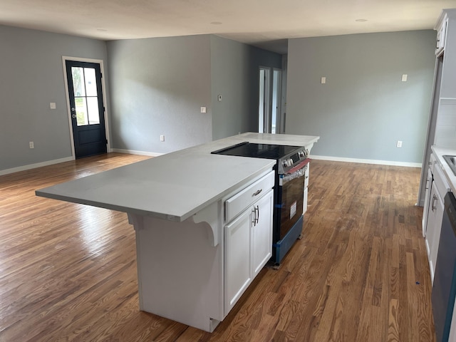 1506 6th St, Monett, MO 65708 - kitchen with stainless steel electric stove, a center island, dark wood finished floors, and white cabinets