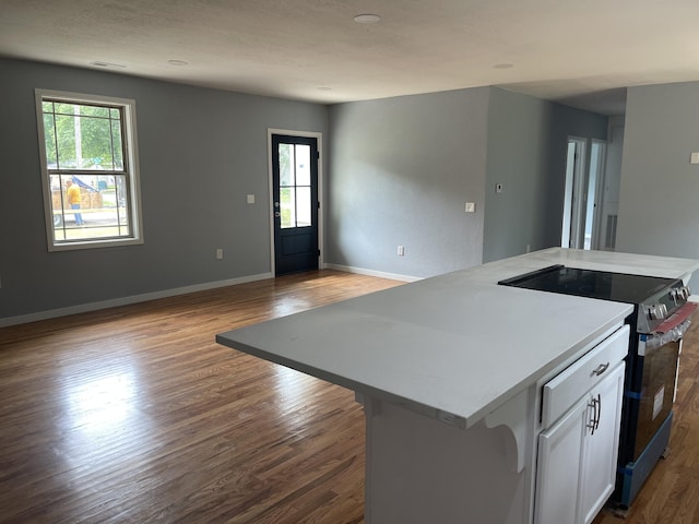 1506 6th St, Monett, MO 65708 - kitchen featuring electric stove, wood finished floors, white cabinets, and open floor plan