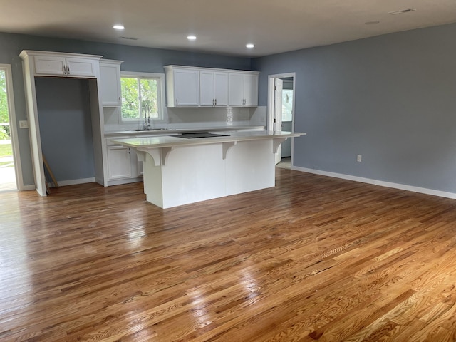 1506 6th St, Monett, MO 65708 - kitchen featuring white cabinets, a center island, light countertops, and recessed lighting