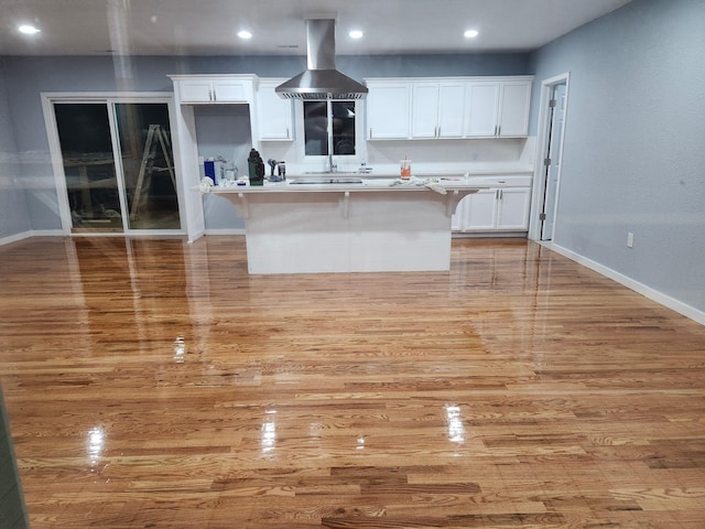 1506 6th St, Monett, MO 65708 - kitchen featuring island exhaust hood, light wood-type flooring, white cabinets, and recessed lighting