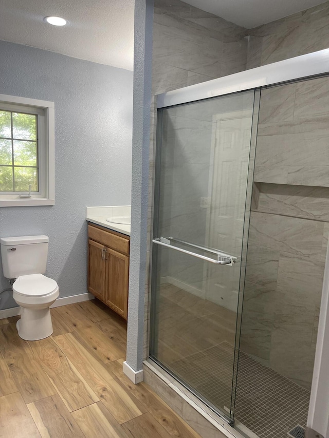1506 6th St, Monett, MO 65708 - bathroom with vanity, wood finished floors, a stall shower, and a textured wall