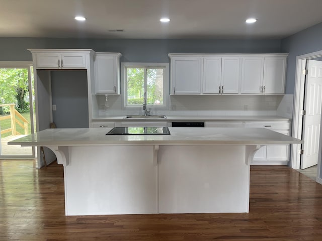 1506 6th St, Monett, MO 65708 - kitchen with white cabinets, black electric stovetop, a kitchen island, decorative backsplash, and recessed lighting