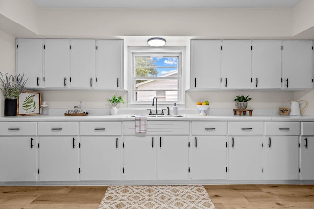 936 W Division St, Springfield, MO 65803 - kitchen featuring white cabinetry, light countertops, and light wood-type flooring