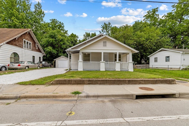 936 W Division St, Springfield, MO 65803 - bungalow-style home with a porch, an outdoor structure, gravel driveway, and a garage