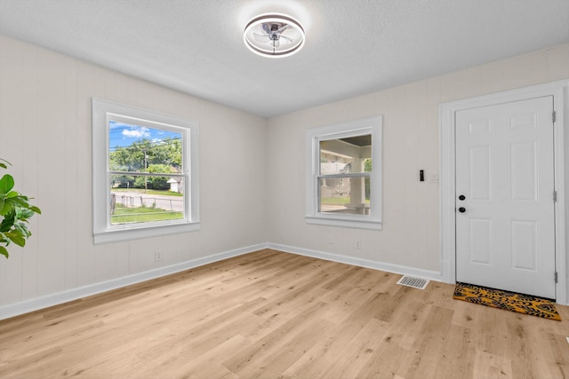936 W Division St, Springfield, MO 65803 - entrance foyer with light wood-style flooring, healthy amount of natural light, and a textured ceiling