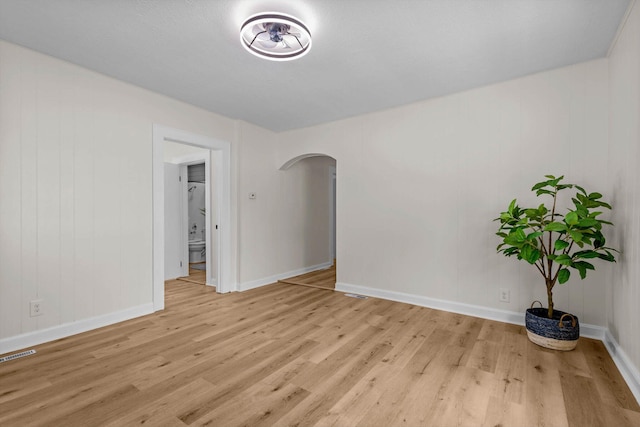 936 W Division St, Springfield, MO 65803 - empty room with arched walkways and light wood-style floors