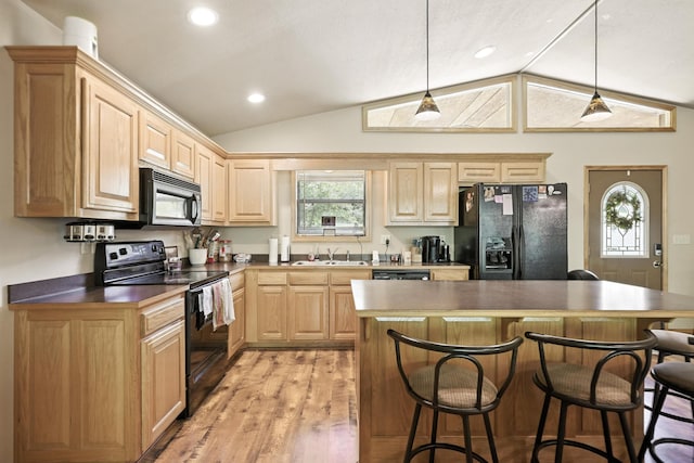 22562 Air Park Dr, Golden, MO 65658 - kitchen with black appliances, vaulted ceiling, light brown cabinetry, a kitchen bar, and light wood finished floors