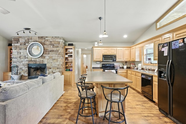 22562 Air Park Dr, Golden, MO 65658 - kitchen featuring black appliances, light brown cabinets, open floor plan, light wood-style flooring, and a breakfast bar