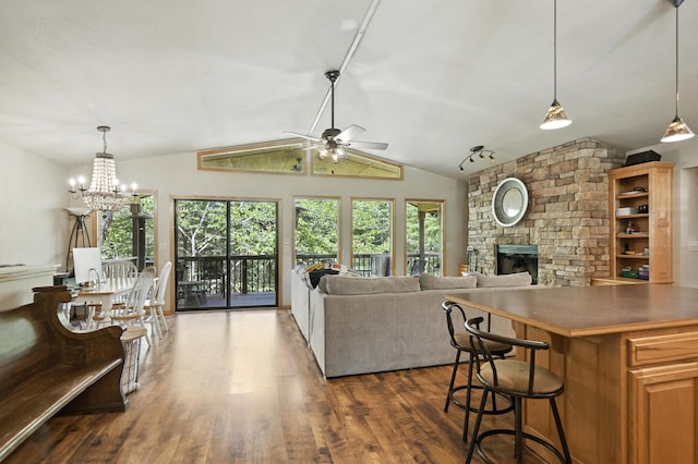 22562 Air Park Dr, Golden, MO 65658 - living room featuring a fireplace, dark wood-style flooring, a ceiling fan, vaulted ceiling, and a chandelier