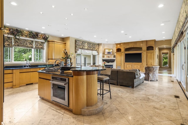 318 S Farm Rd Unit 193, Springfield, MO 65809 - kitchen with stainless steel oven, dark countertops, recessed lighting, arched walkways, and an island with sink